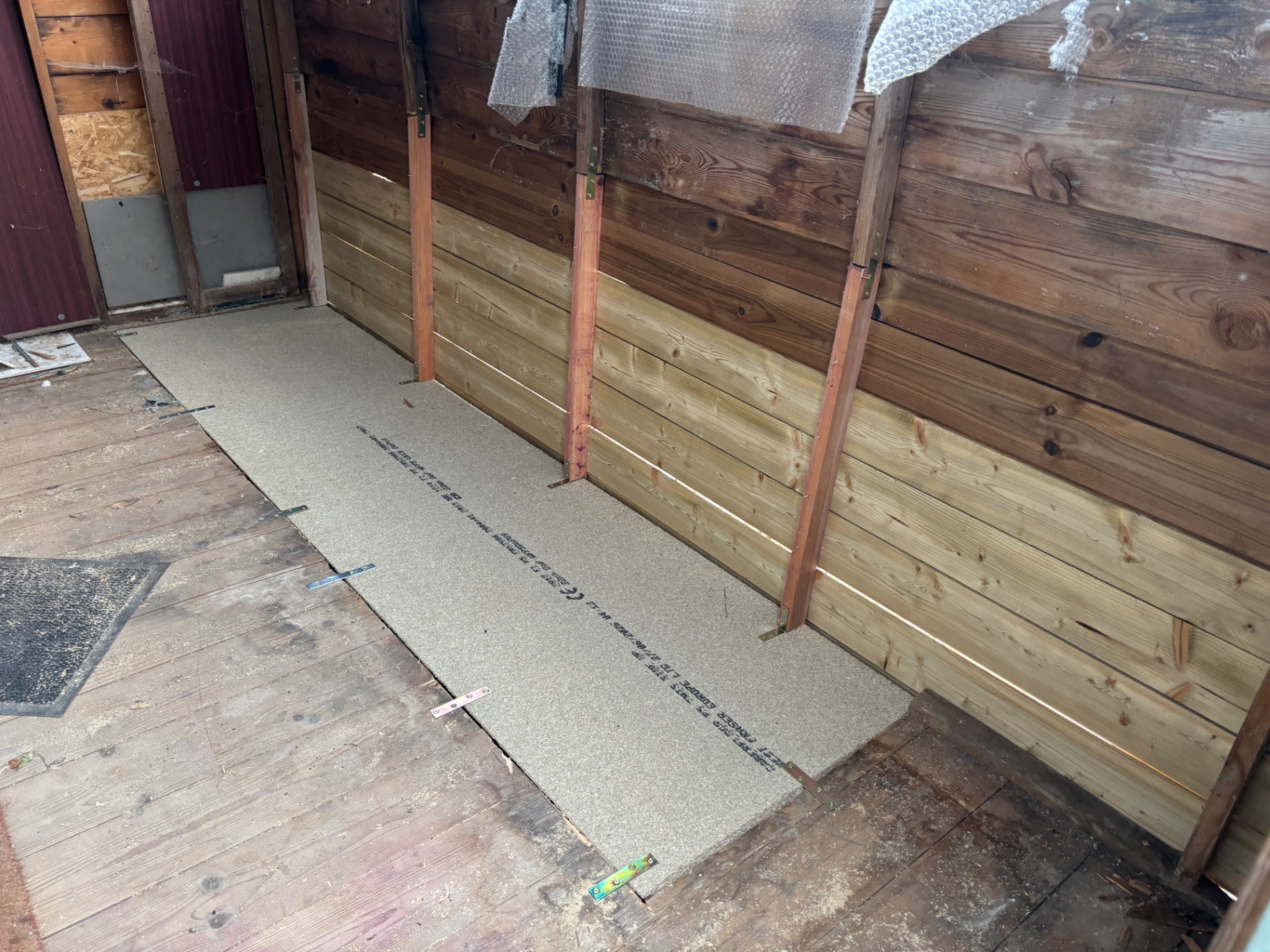 New treated shiplap boards fitted to the inner wall and floor panel renewed — after