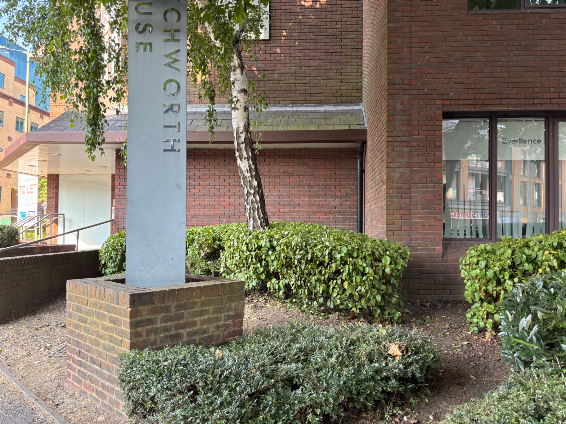 Frontage by the building entrance trimmed back and tidied — after